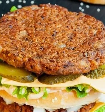 Veganer Rindfleischburger auf einem Teller mit frischem Gemüse