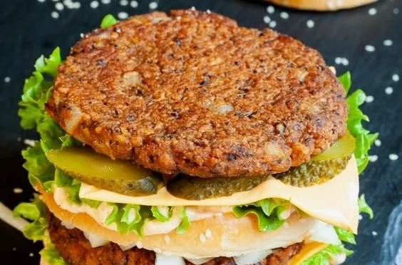 Veganer Rindfleischburger auf einem Teller mit frischem Gemüse