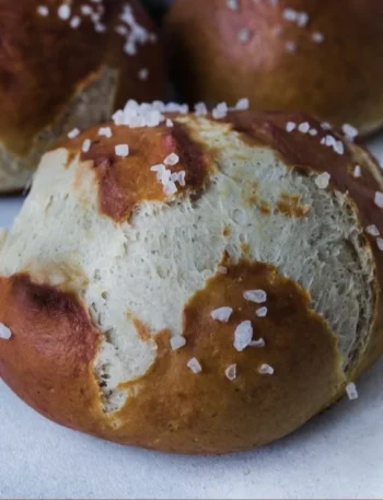 Frisch gebackene weiche Brezelbrötchen auf einem Holzbrett