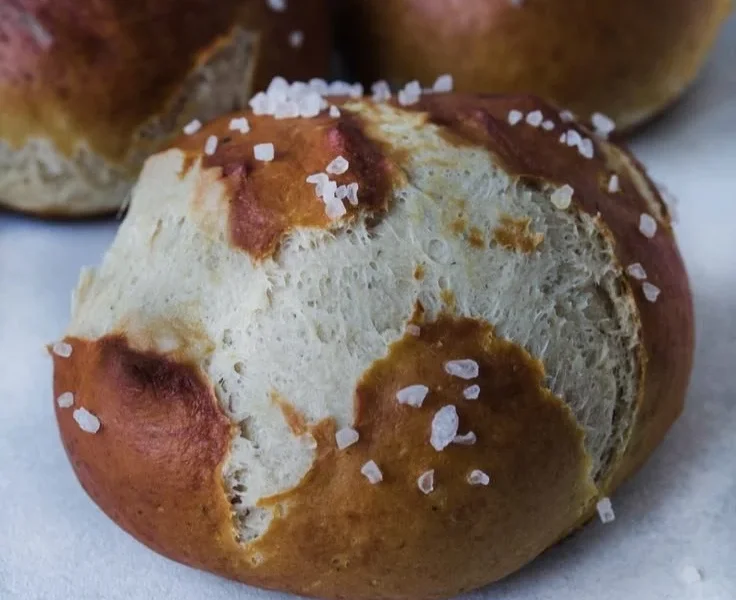 Frisch gebackene weiche Brezelbrötchen auf einem Holzbrett