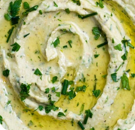 Zitronen- und Kräuter-Weißbohnendip in einer Schüssel, serviert mit frischem Brot.