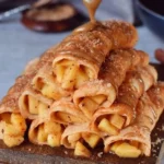 Leckere Apfel-Zimt-Crepes auf einem Teller, garniert mit Äpfeln und Zimt.