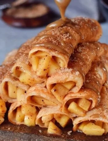 Leckere Apfel-Zimt-Crepes auf einem Teller, garniert mit Äpfeln und Zimt.