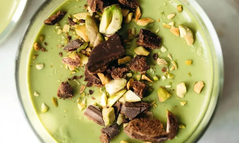 Schüssel mit Chocolate Hazelnut Matcha Pudding, dekoriert mit Nüssen und Schokolade