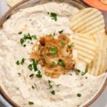 Cremiger veganer Zwiebel-Dip in einer Schale, ideal für Snacks und Partys.