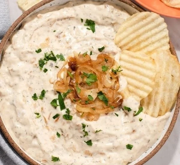 Cremiger veganer Zwiebel-Dip in einer Schale, ideal für Snacks und Partys.