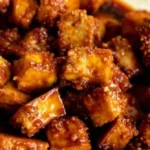 Crispy Gochujang Tofu serviert auf einem Teller mit frischem Gemüse.