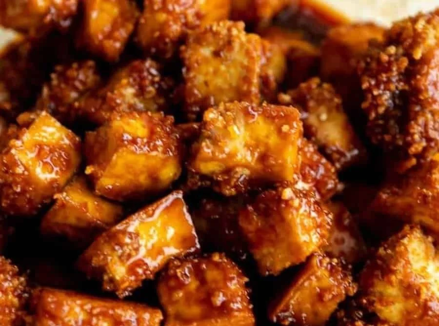 Crispy Gochujang Tofu serviert auf einem Teller mit frischem Gemüse.