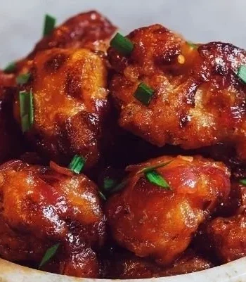 Veganes General Tso's Blumenkohl serviert mit Reis und Sesam