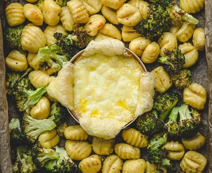 Ofenkäse mit Brokkoli und Gnocchi auf einem Teller serviert