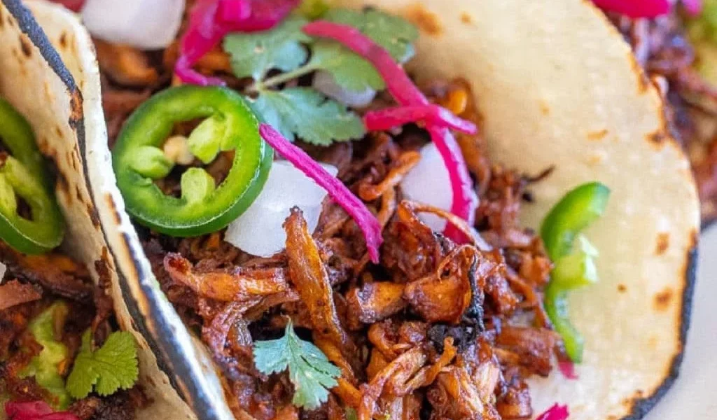 Schnelle vegane Carnitas mit Pilzen auf einem Teller serviert.