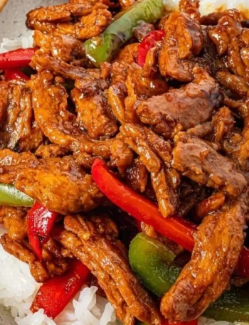 Leckeres veganes Pfeffersteak mit buntem Gemüse auf einem Teller.