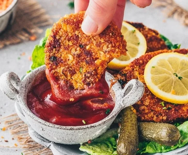 Vegane Schnitzel aus roten Linsen auf einem Teller, frisch zubereitet.
