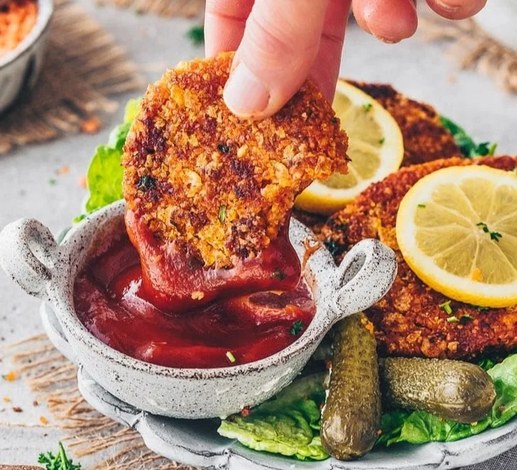 Vegane Schnitzel aus roten Linsen auf einem Teller, frisch zubereitet.
