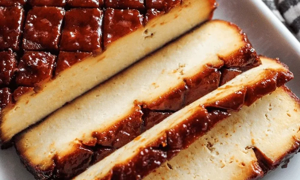 Veganes Hauptgericht Brauner Zucker-Tofu auf einem Teller garniert